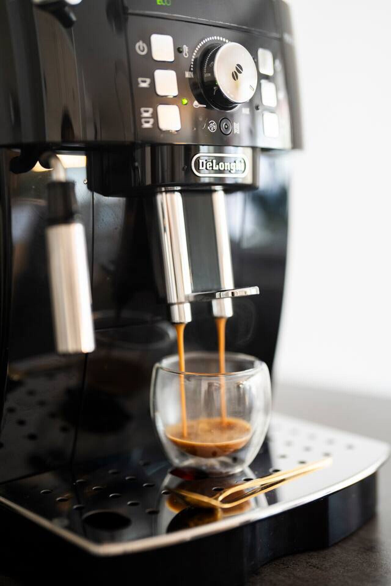 Eine DeLonghi-Espressomaschine, die Kaffee in ein Glas füllt.