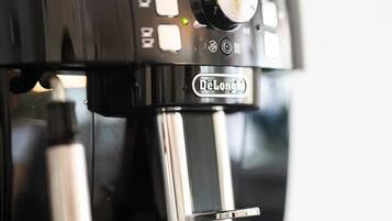 Eine DeLonghi-Espressomaschine, die Kaffee in ein Glas füllt.