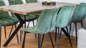 A dining area with a wooden table and green upholstered chairs. There are two wall-mounted paintings above the table. - 90m2 Loft I Kaffee I Terrasse I E-Parkplatz (Rosenheim)
