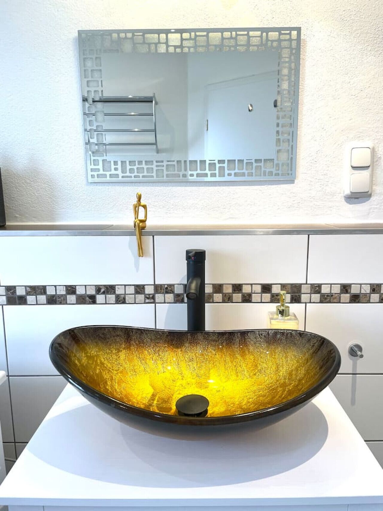 A bathroom with a large, oval vessel sink, a wall-mounted mirror, and a towel rack.