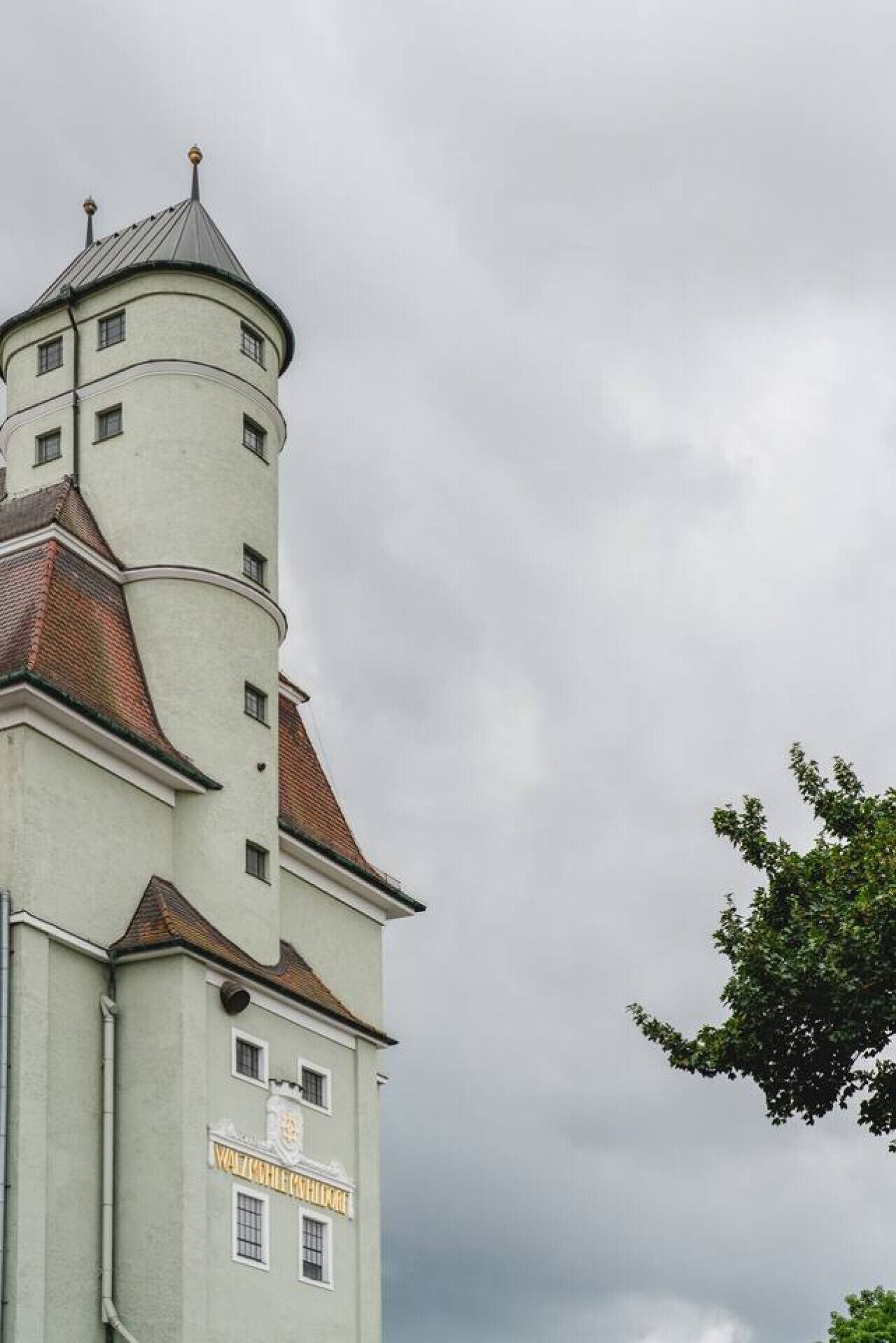 A historic building with a prominent tower and a sign reading "WALZSHEIM HOTEL".