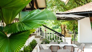 Un patio con mobiliario exterior, una escalera y una estatua.
