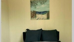Ein Schlafzimmer mit einem Bett, zwei Kissen und einem Bild an der Wand.