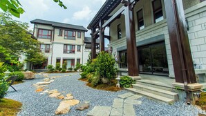 A traditional Japanese-style building with a gravel pathway and greenery. - Wu Yi Creekside Homestay (Jingdezhen)