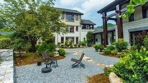 A two-story house with a garden patio, stone pathway, and outdoor seating area. - Wu Yi Creekside Homestay (Jingdezhen)
