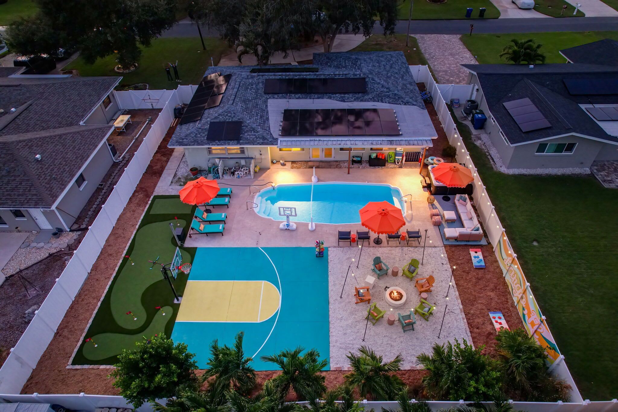 Una propietat residencial amb piscina, zona d'estar a l'aire lliure i pista de bàsquet.