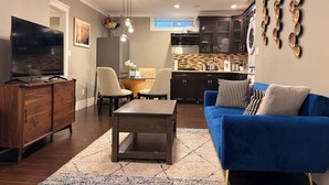 Una sala de estar moderna con televisor, sofá y comedor.