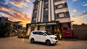 Un immeuble hôtelier à plusieurs étages, sur lequel on peut lire l’inscription : « Hôtel The Premier Dwarka ».