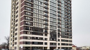 Un edificio alto con varios pisos, ventanas amplias y balcones.