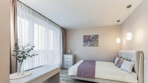 Un dormitorio moderno con cama, mesita de noche y escritorio.