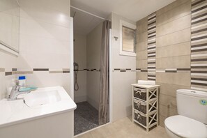 A bathroom with a white sink, a toilet, and a shower area. - Sol y Mar by Rentallorca (Can Picafort)