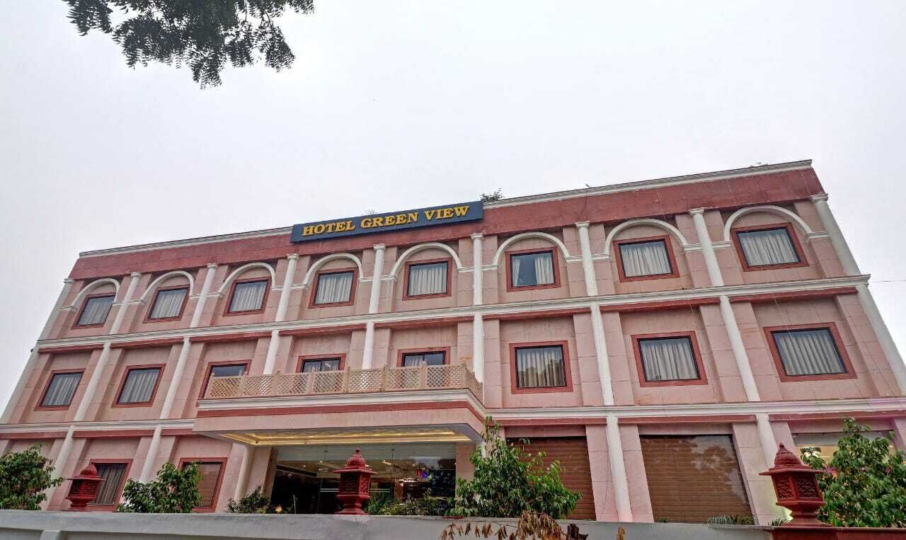 A multi-story building with a sign reading "HOTEL GREEN VIEW."