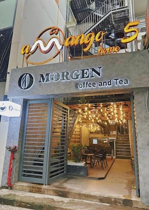 A coffee shop named MORGEN with an outdoor seating area and a staircase leading to the entrance.