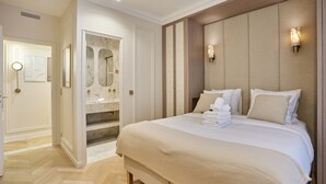 Ein Hotelzimmer mit einem großen Bett, einem Schminktisch mit Spiegel und einem begehbaren Kleiderschrank.