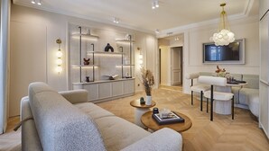 Ein modernes Wohnzimmer mit Sofa, Couchtisch, Fernseher und integrierten Regalen.