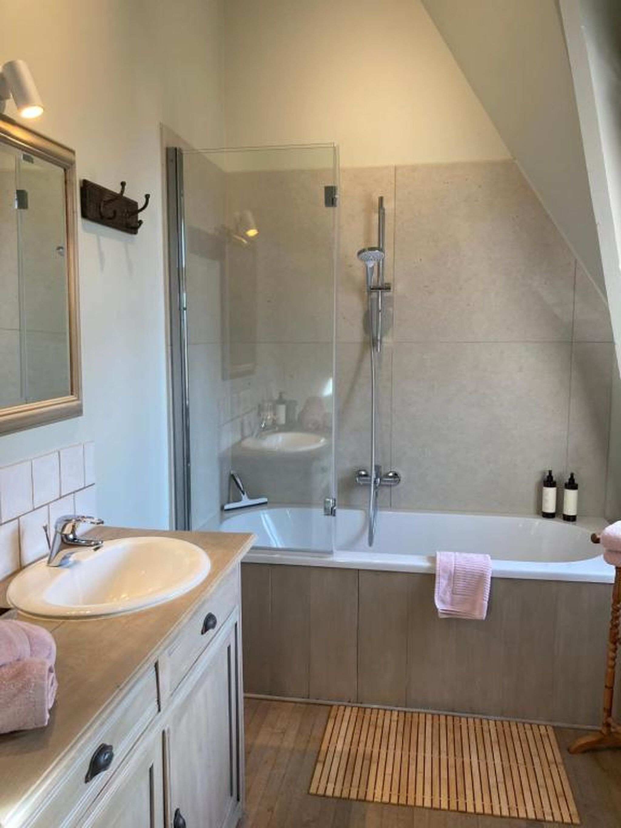A modern bathroom with a glass-enclosed shower, a freestanding bathtub, and a vanity with a sink.