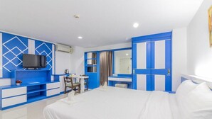 A hotel room with a bed, a desk, a chair, a television, and a bathroom with a mirror and curtains. - Relaxed Delux Double | Cozy Stay with Free Parking (Bangkok)