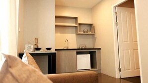 Eine kleine Küche mit Spüle, Schränken und einem Kühlschrank.