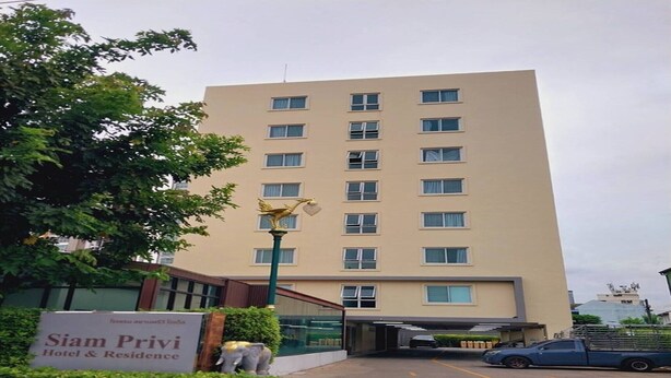 Un immeuble à plusieurs étages portant une enseigne indiquant « Siam Privi Hotel & Residence ».