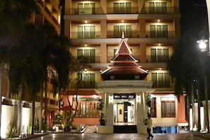 A hotel entrance with a traditional pagoda-style structure, multiple balconies, and a well-lit facade. - Twin Escape in Pattaya | Free Pool & Parking (Pattaya)