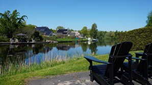 Une vue sur le lac, avec des chaises et un chemin menant à un bâtiment.
