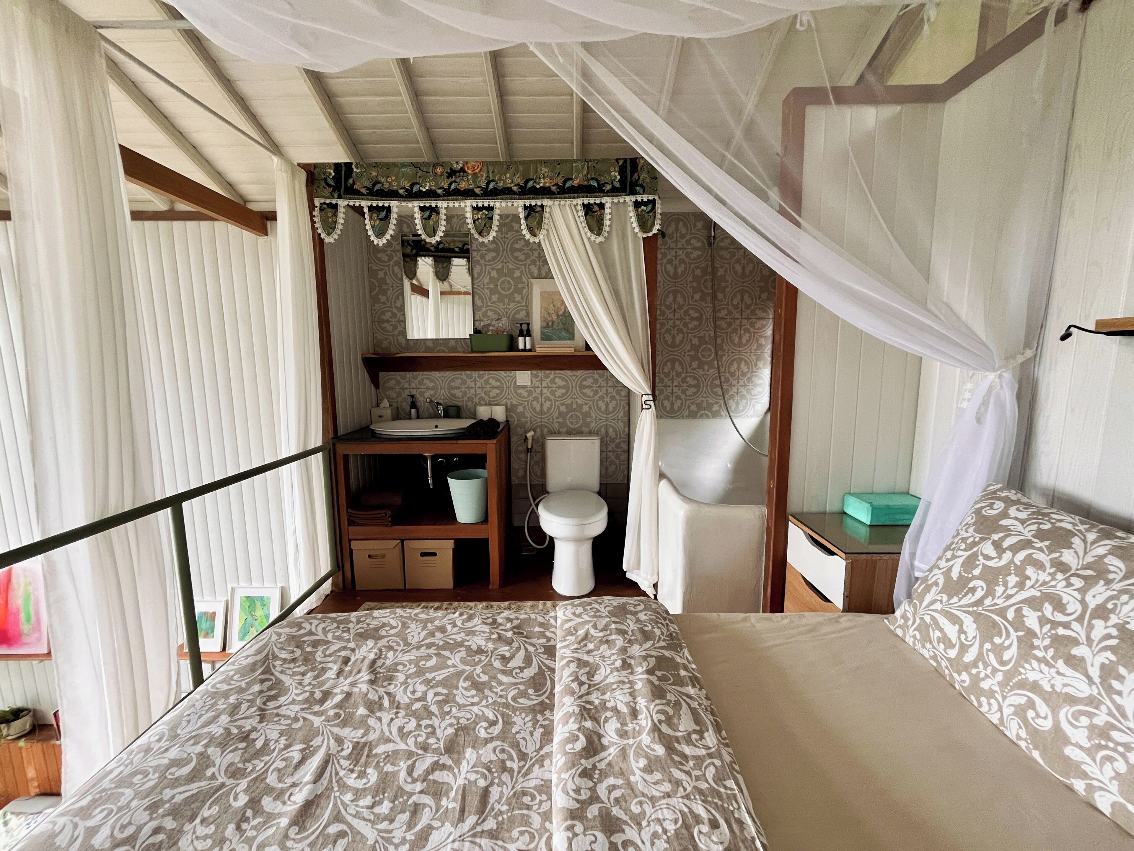 Un dormitorio con cama a dosel, mesita de noche, lavabo e inodoro.