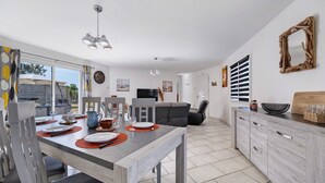 Una cocina moderna con comedor, sofá y un amplio ventanal.