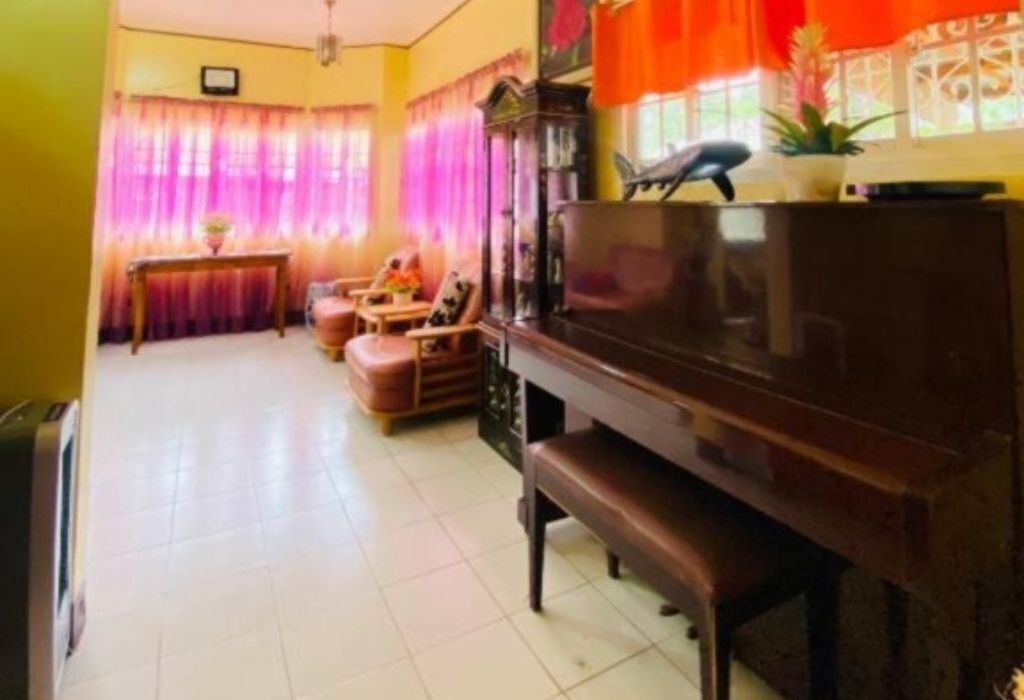 A living room with a piano, a sofa, a coffee table, and curtains.