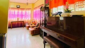 A living room with a piano, a sofa, a coffee table, and curtains.