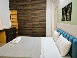 A bedroom with a bed, a wardrobe, and a nightstand.
