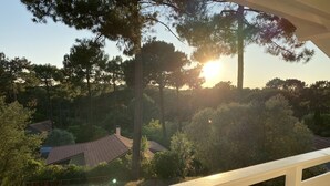 Área de piscina com vista para um bairro residencial e árvores.