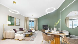 Una sala de estar moderna con sofá, mesa de centro y comedor con sillas y una mesa.
