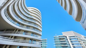 Un moderno edificio de varios pisos con fachada curva y balcones.