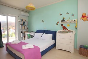 Un dormitorio con cama, escritorio, armario y ventana con vistas.