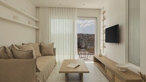 A modern living room with a sofa, coffee table, and a TV mounted on the wall. - Swan Lake (Ioannina)