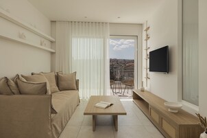 Uma sala de estar moderna com sofá, mesa de centro e televisão fixada na parede.