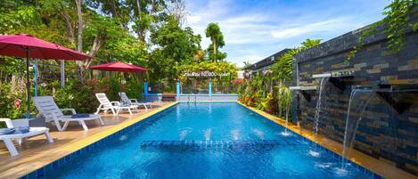 Utomhuspool, parasoller och solstolar