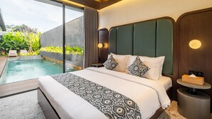 A modern hotel room with a large bed, a small bedside table, a round bedside table, and a view of an outdoor swimming pool. - Modern 3bedroom villa with calm surrounding (Kabupaten Gianyar, Bali)