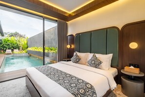 Una habitación de hotel moderna con una cama grande, una mesita de noche pequeña y otra redonda, y vistas a una piscina al aire libre.