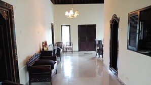 A hallway with a polished floor, wooden furniture, and a chandelier. - Madesimon Villa (Payangan)