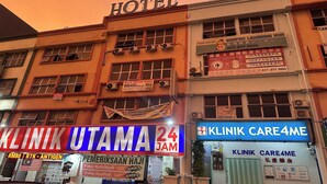 A building with a sign for a hotel, a 24-hour clinic, and a learning center. - Hotel No.1 Lodge (Nilai)