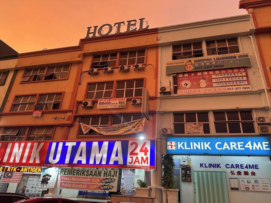 Um edifício com um letreiro para um hotel, uma clínica 24 horas e um centro de aprendizado.