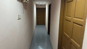 A narrow hallway with a door at the end, a light switch on the wall, and a ceiling-mounted air conditioning unit. - Hotel No.1 Lodge (Nilai)