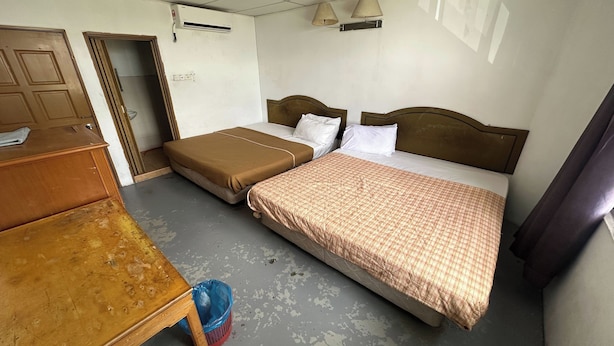 A room with two beds, a wooden dresser, and a blue trash bin. - Hotel No.1 Lodge (Nilai)
