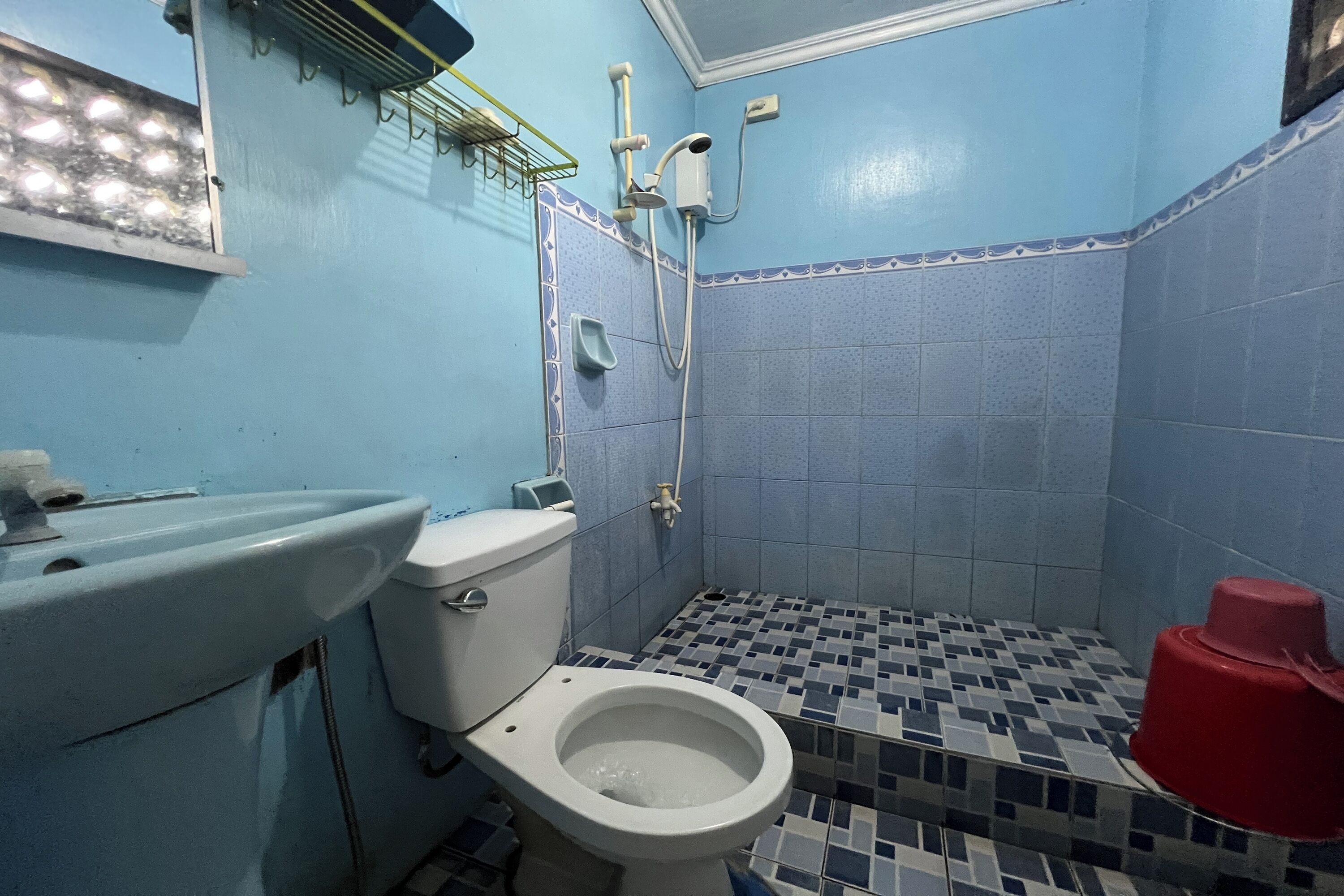 Un baño con inodoro, lavamanos y ducha.