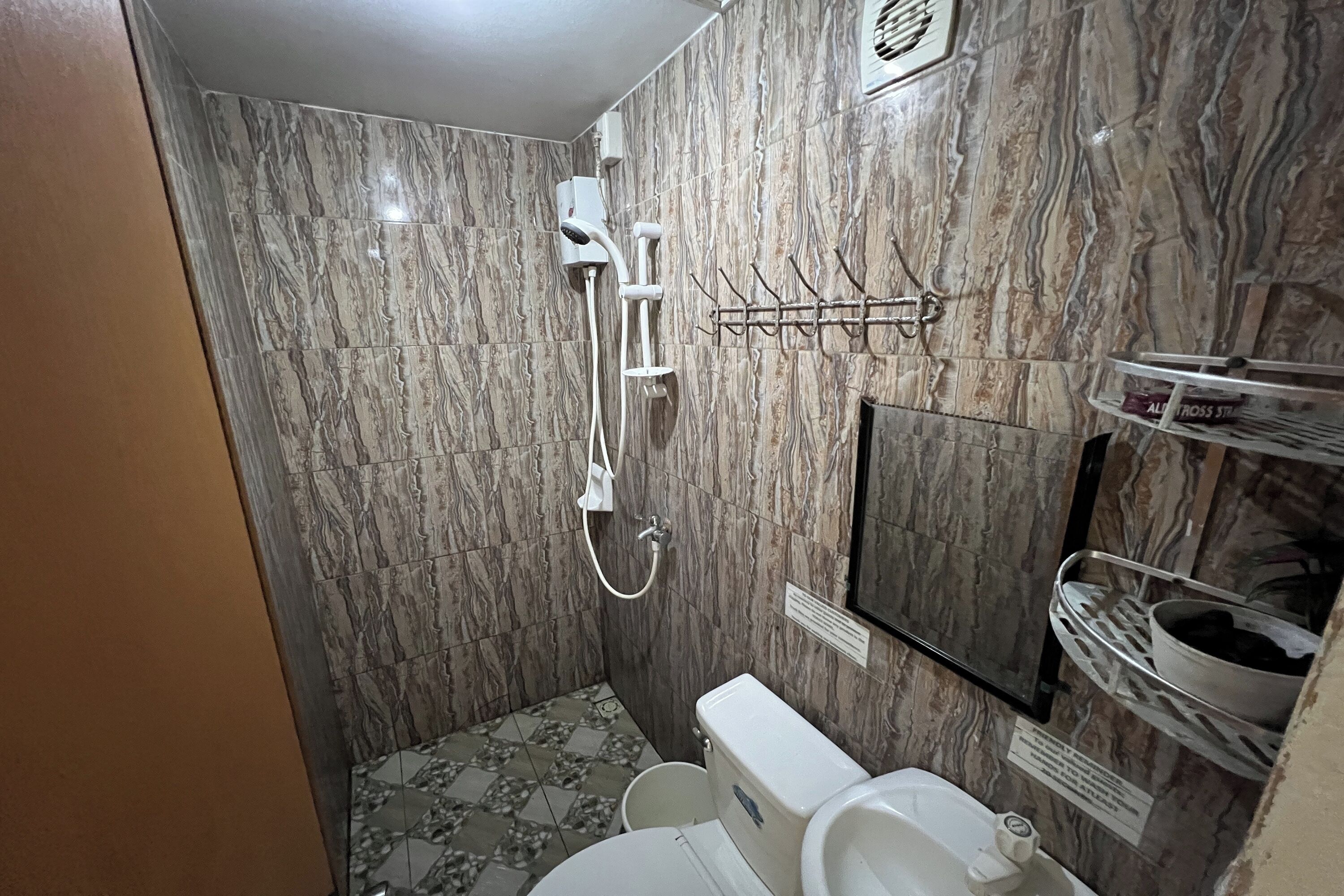 A bathroom with a shower, toilet, and sink.