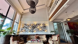 A lobby with a large wall art piece, wooden furniture, and a ceiling light fixture. - D' Leonor Inland Resort And Adventure Park (Davao)