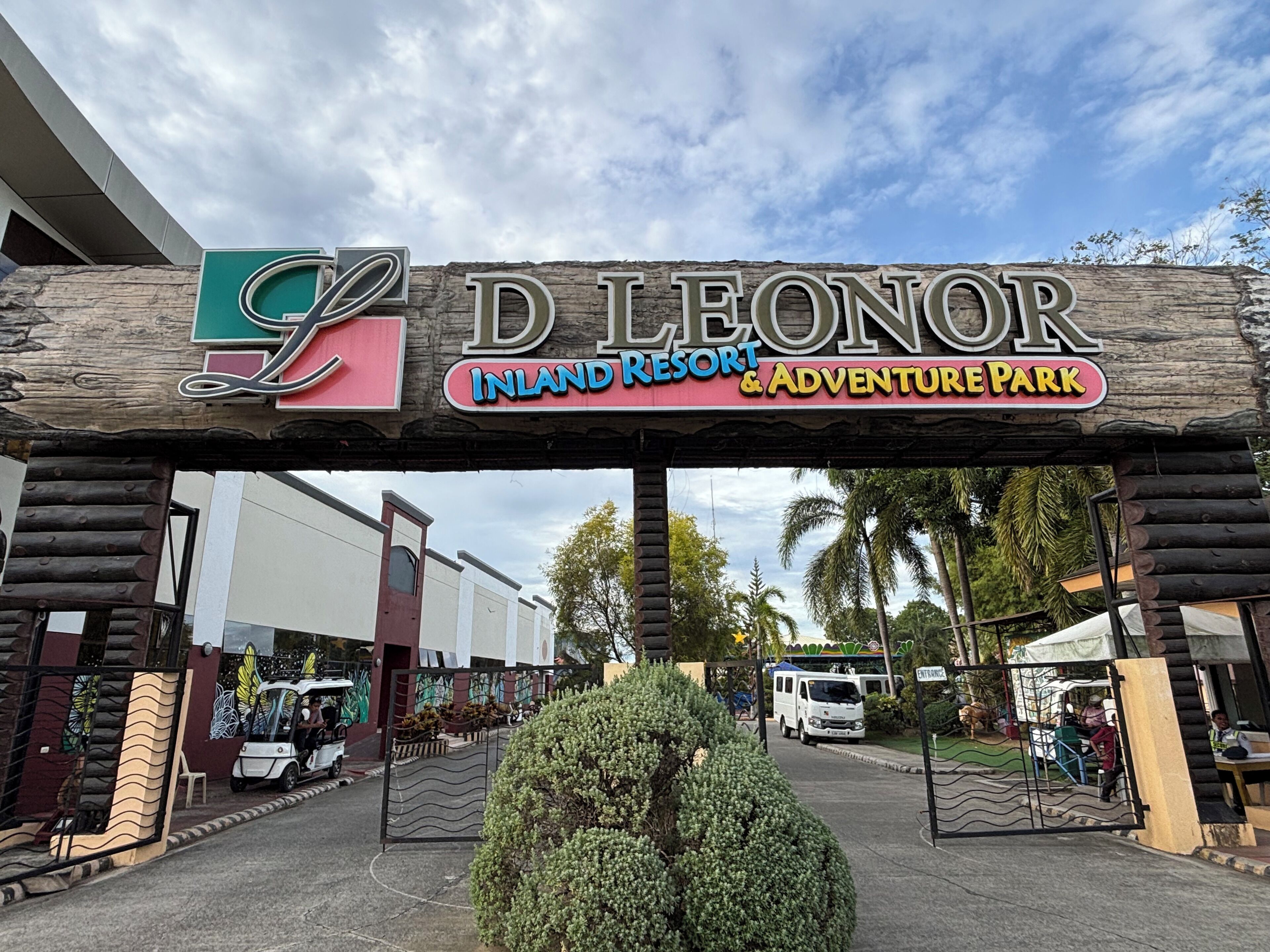 The entrance to D Leonor Inland Resort & Adventure Park with a wooden archway and a sign.