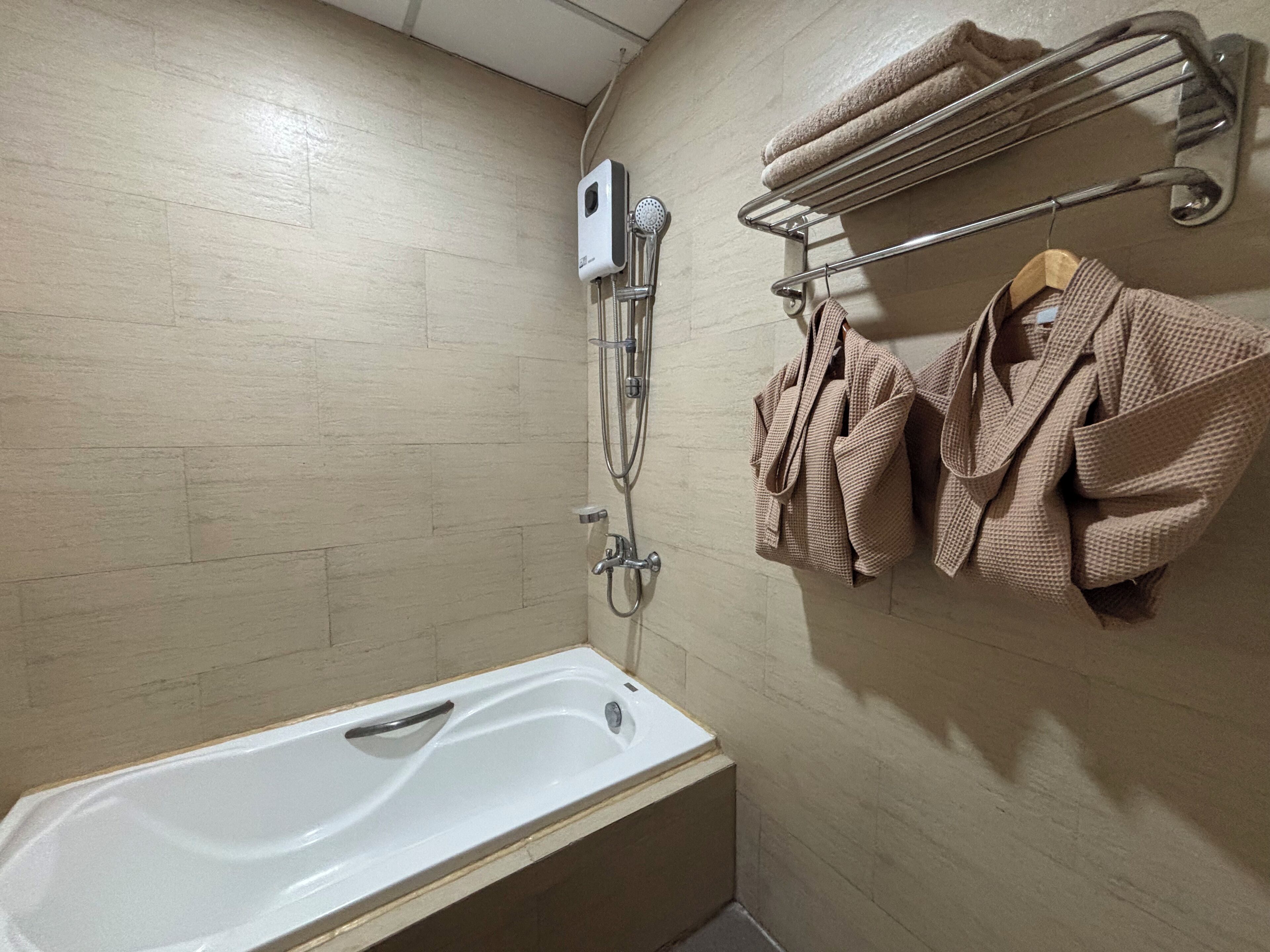 Une salle de bain équipée d’une baignoire, d’une douche et d’un porte-serviettes avec des serviettes.