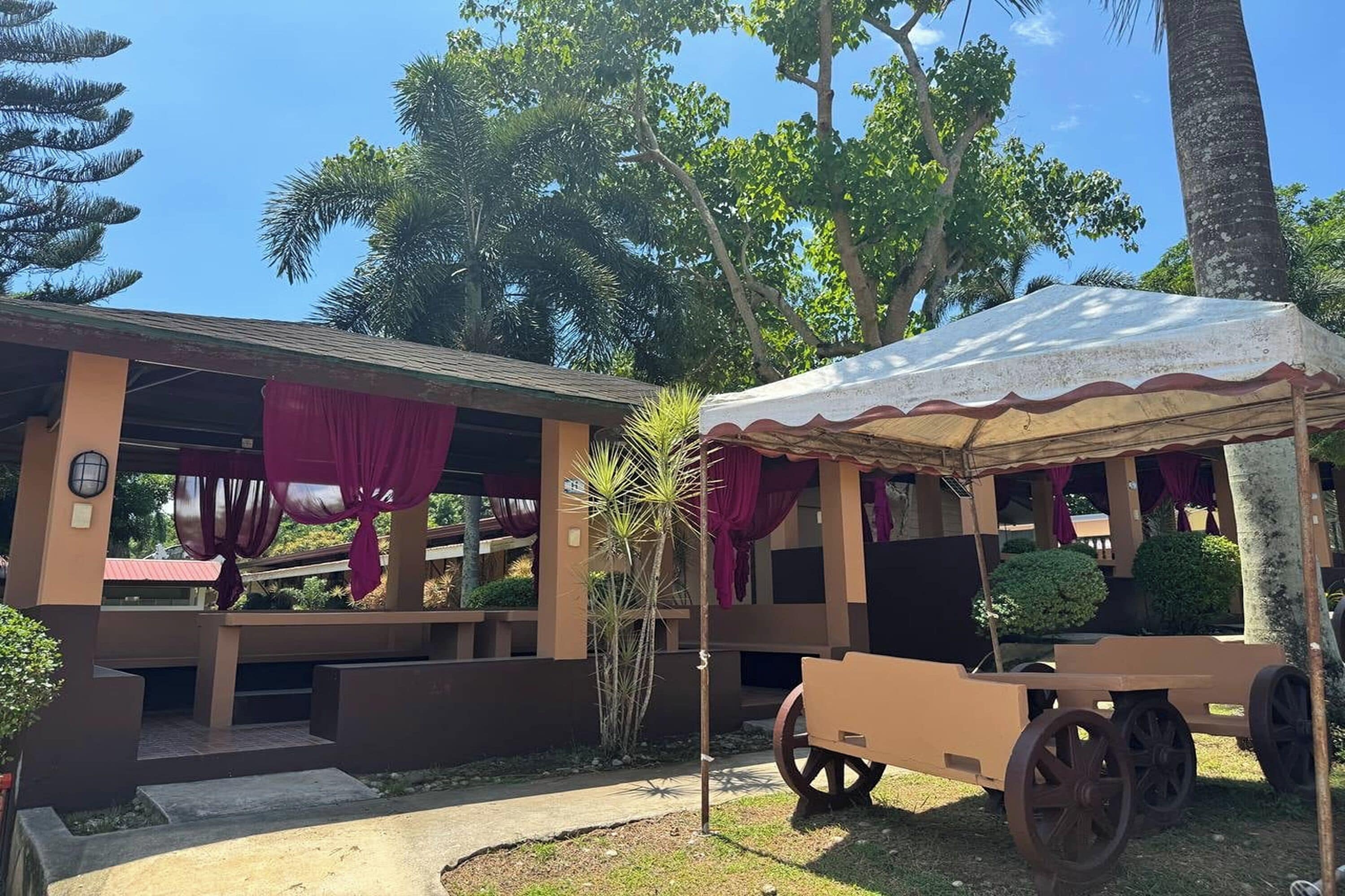 A building with a covered outdoor seating area and a cart.